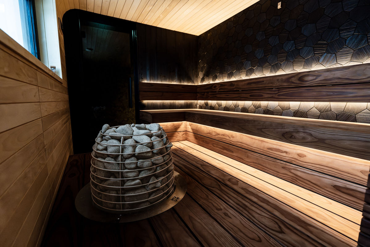 Warm-lit sauna interior with glowing heater stones — BioHack101 hero background